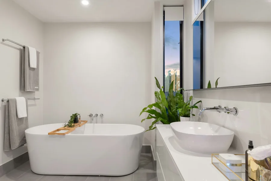 Light bathroom with freestanding white bath and oval basin